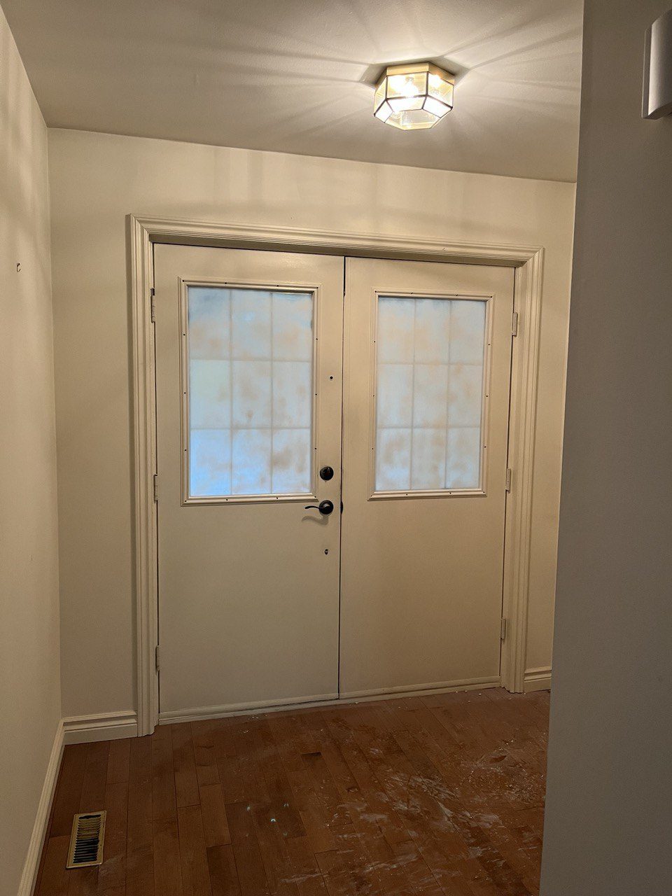 Front entry after renovation, modern black door with marble flooring