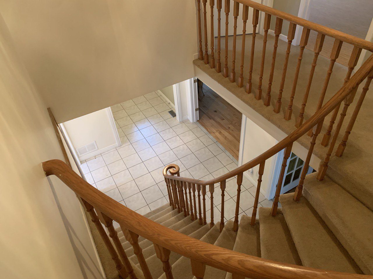 Staircase before renovation, carpeted treads and painted oak spindles